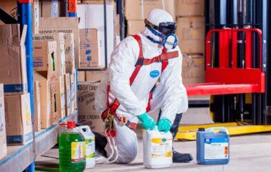 Worker in protective clothing handling chemicals