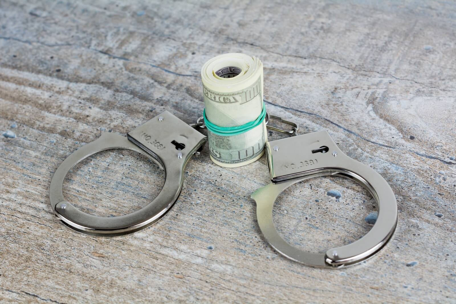 a pair of handcuffs and a roll of money on a table