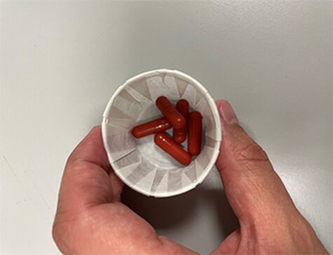 Fecal transplant pills in a white cup