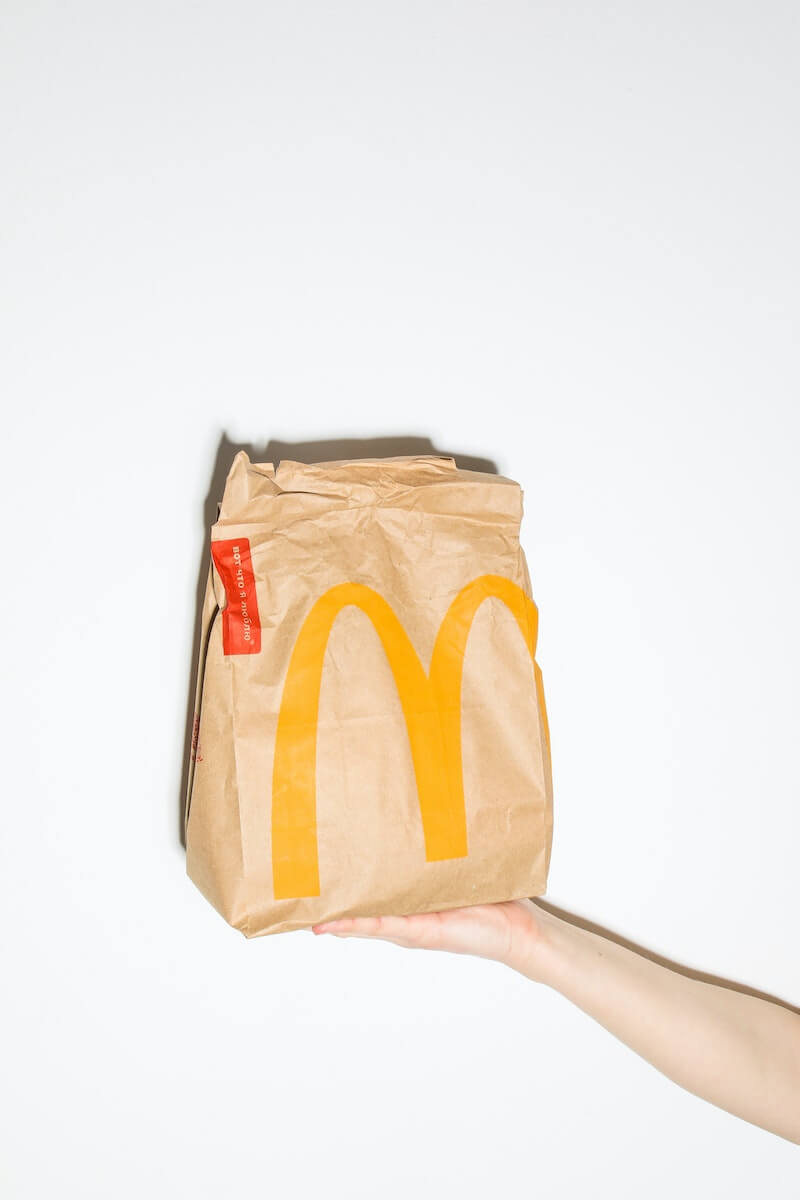 A person holding a bag of McDonald's food