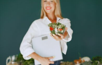 Woman Holding a Salad and Smiling 