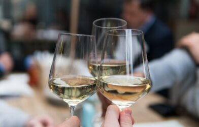 People clinking glasses of white wine