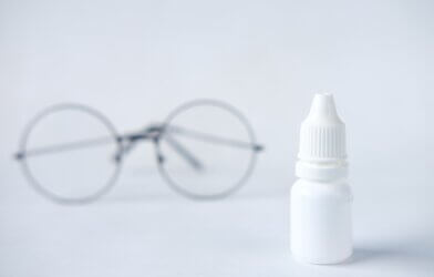white eye drop bottle and glasses