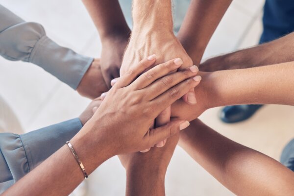 Teamwork concept: Hands together in a group huddle