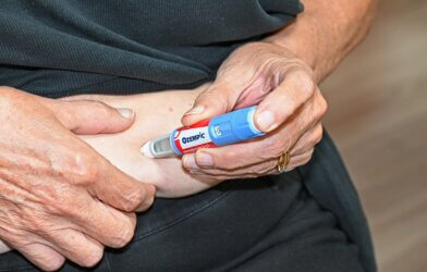 Patient injecting themself in the stomach with an Ozempic (semaglutide) needle.