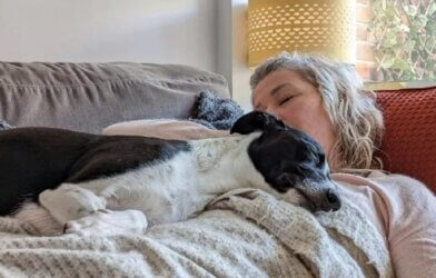 woman sleeping on the couch and her dog laying on top of her