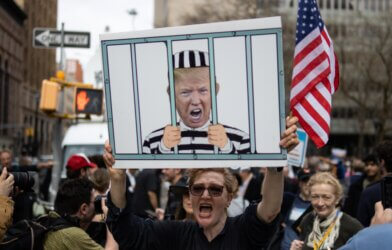 Woman Counter Protester with a Sign of Trump in Jail Outside the Courthouse during the Trump Indictment in New York City