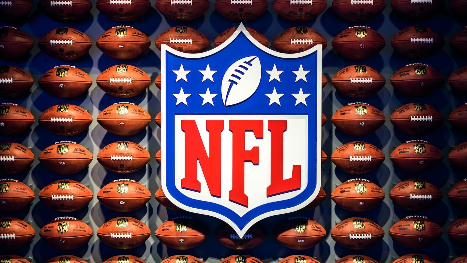 NFL logo and a wall of footballs