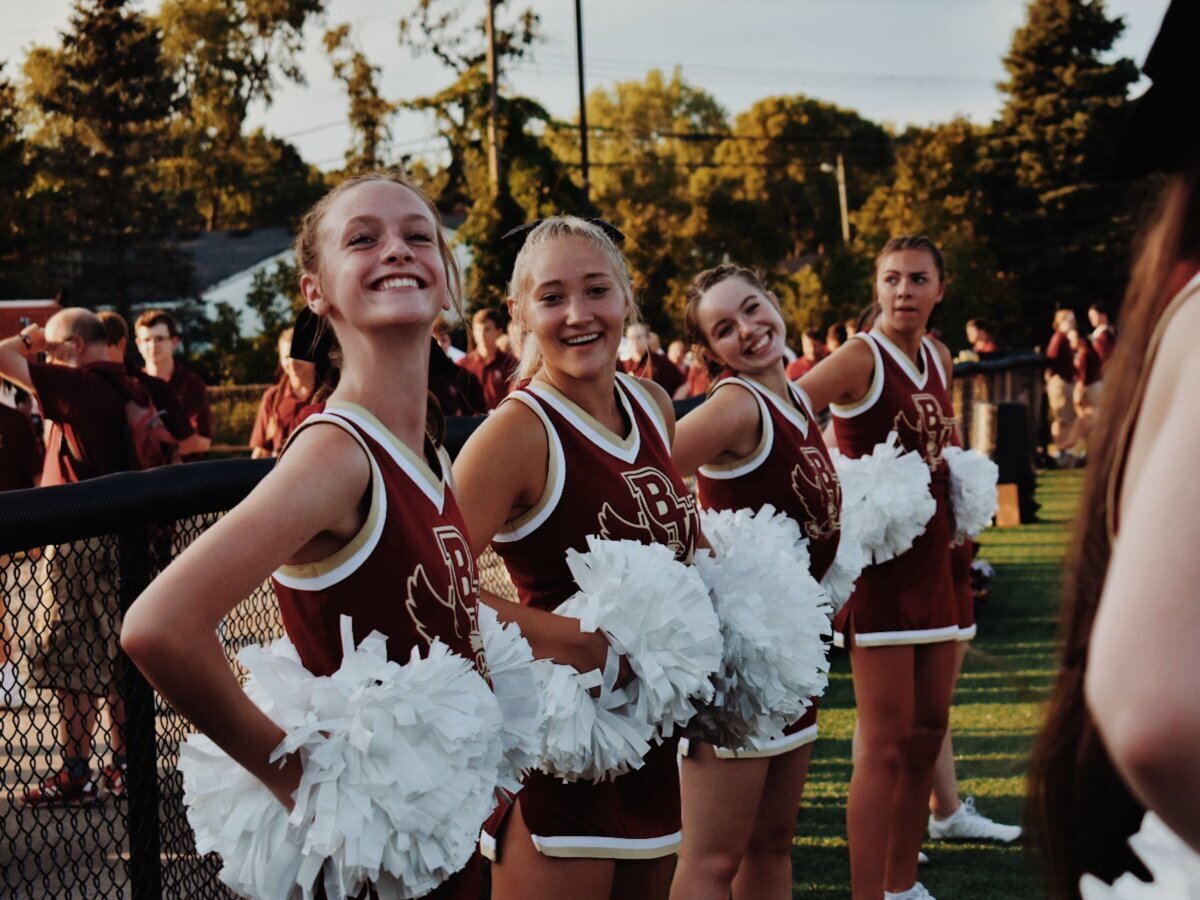 High school cheerleaders in uniform at game.