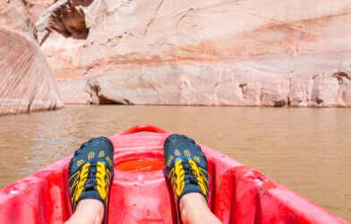 Someone kayaking wearing water shoes