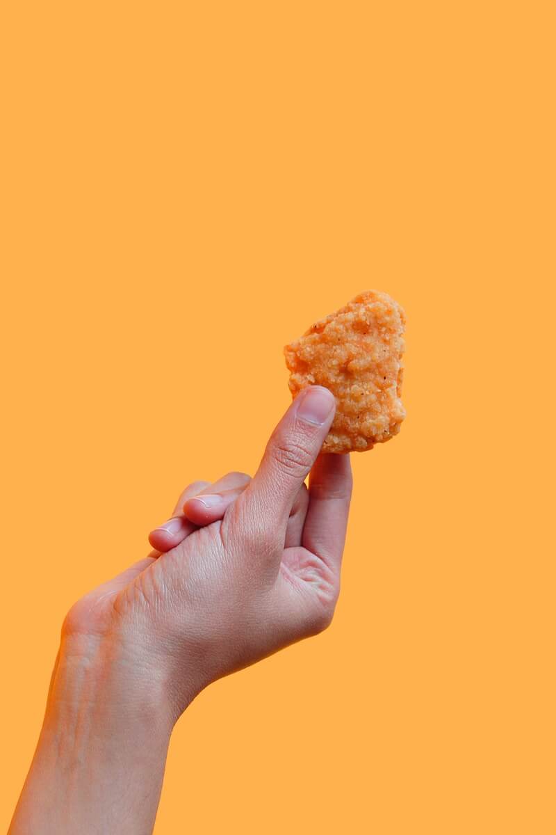 Someone holding a chicken nugget