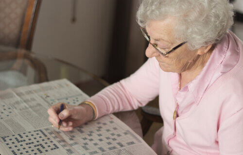 Older woman doing a crossword puzzle.