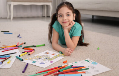 Child coloring drawing on floor at home