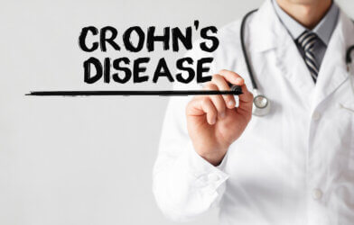 Doctor writing word Crohn's disease with marker