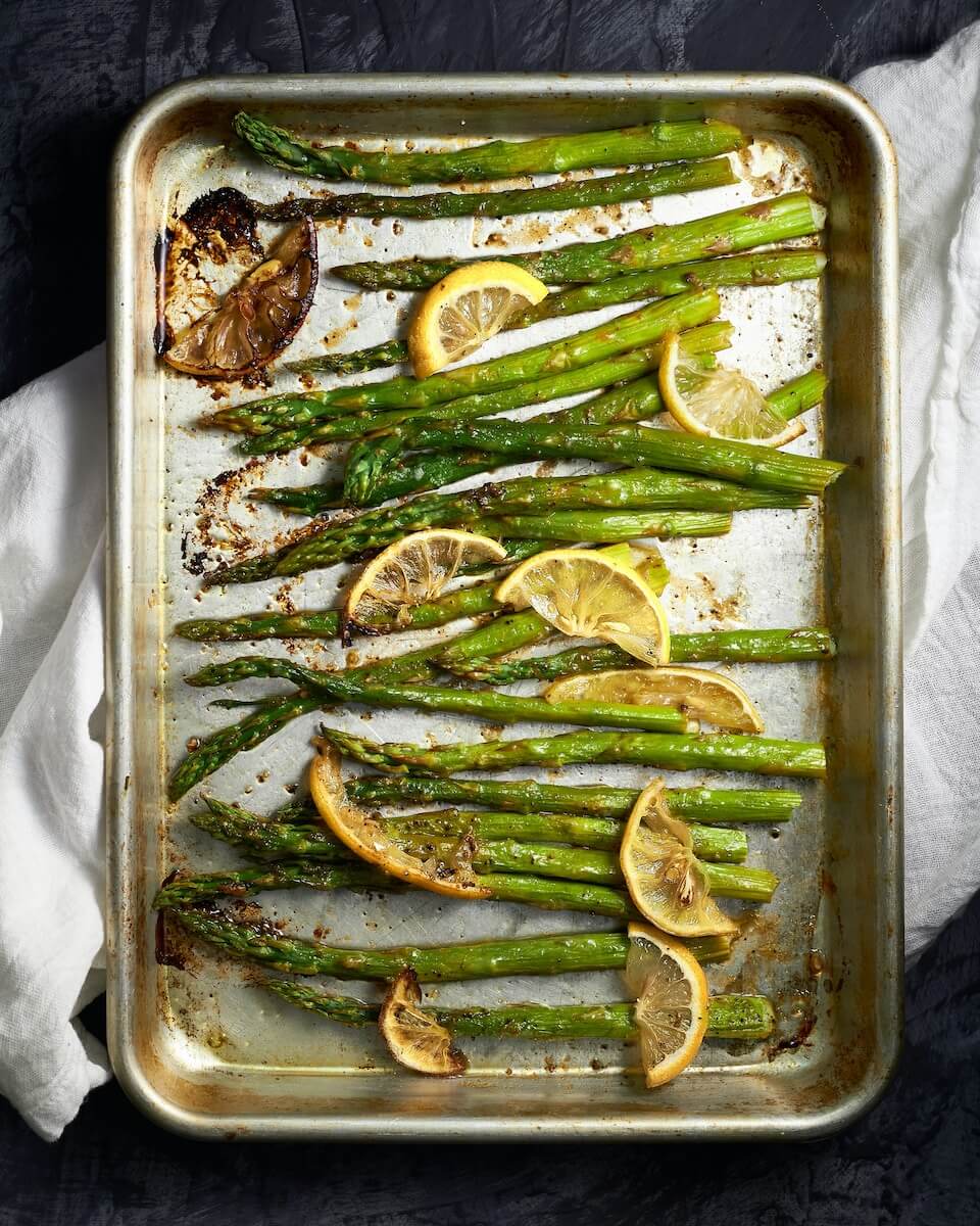 A tray of asparagus seasoned with lemon