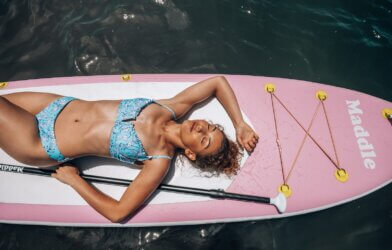A woman sunbathing on a paddle board