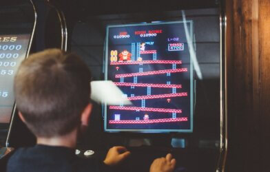 A boy playing the Donkey Kong arcade game