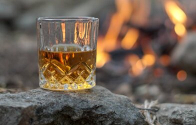 A glass of Scotch near a bonfire