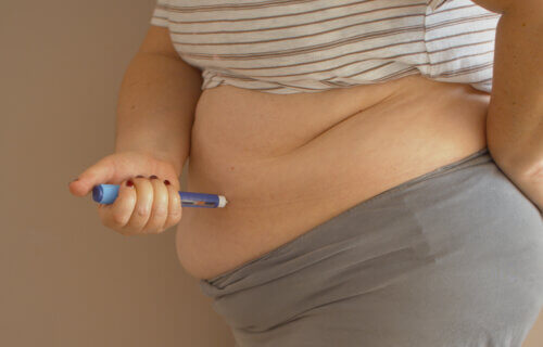 Overweight woman applying medicine injection