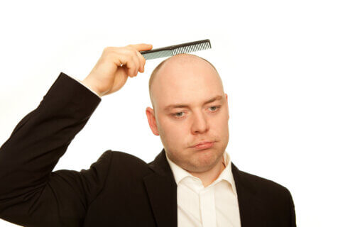 business man with comb is sad about hair loss