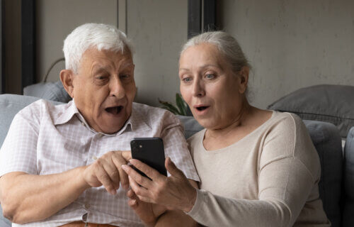 retired couple looking at game on cellphone
