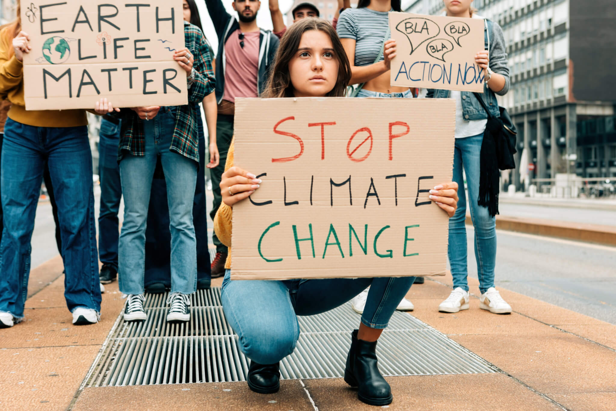 worried young woman holding up a stop climate change sign