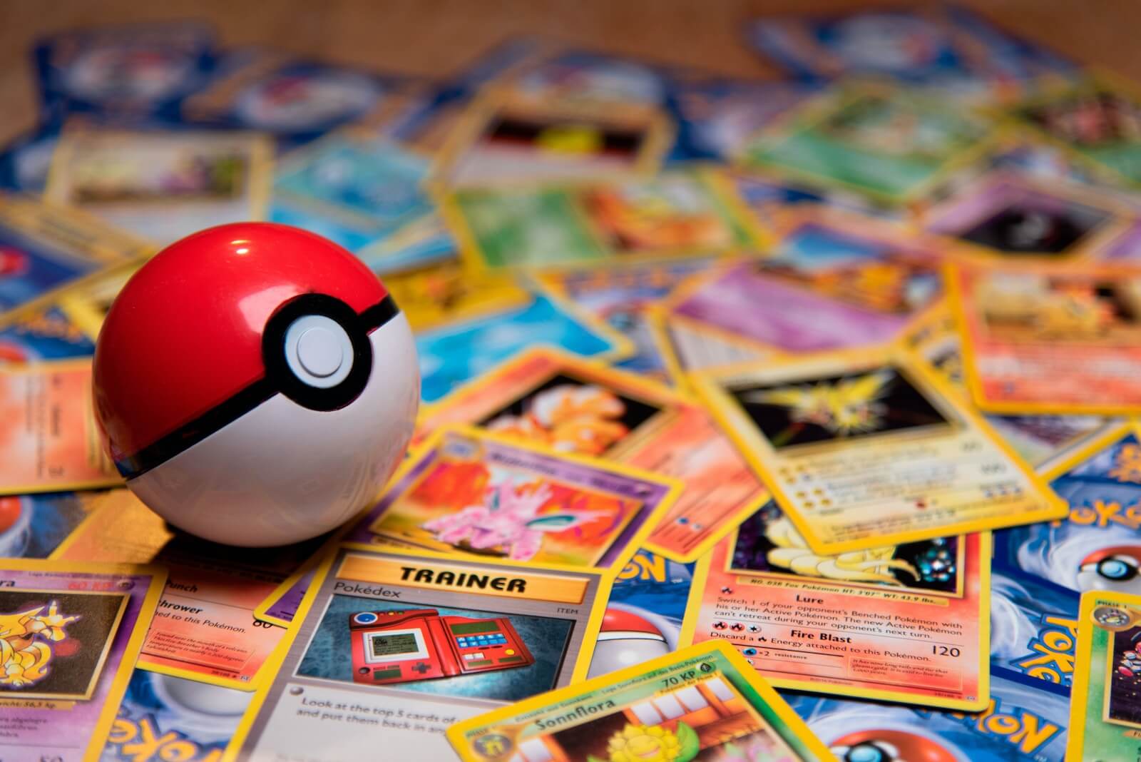 red and white Pokéball on a pile of PTCG cards Photo by Thimo Pedersen