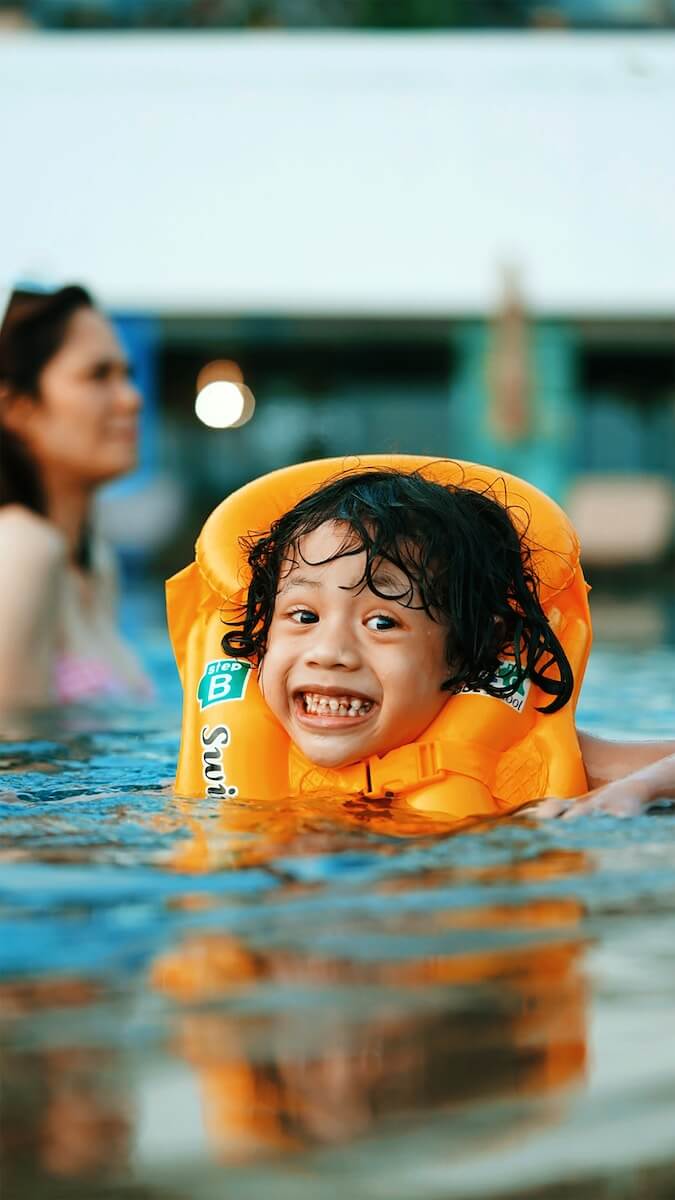 A child wearing a life vest in a pool