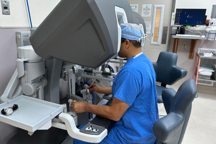 Transplant surgeon Adeel Khan, MD, controls a surgical robot.