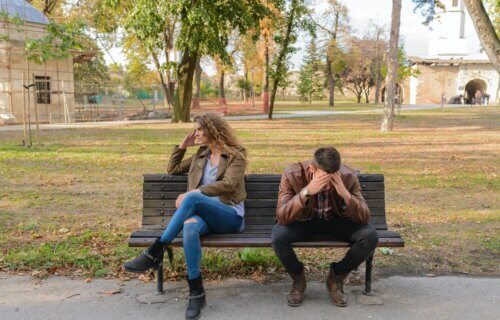 Stressed man and woman sitting on a park bench