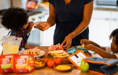 A mother packing school lunches with her children