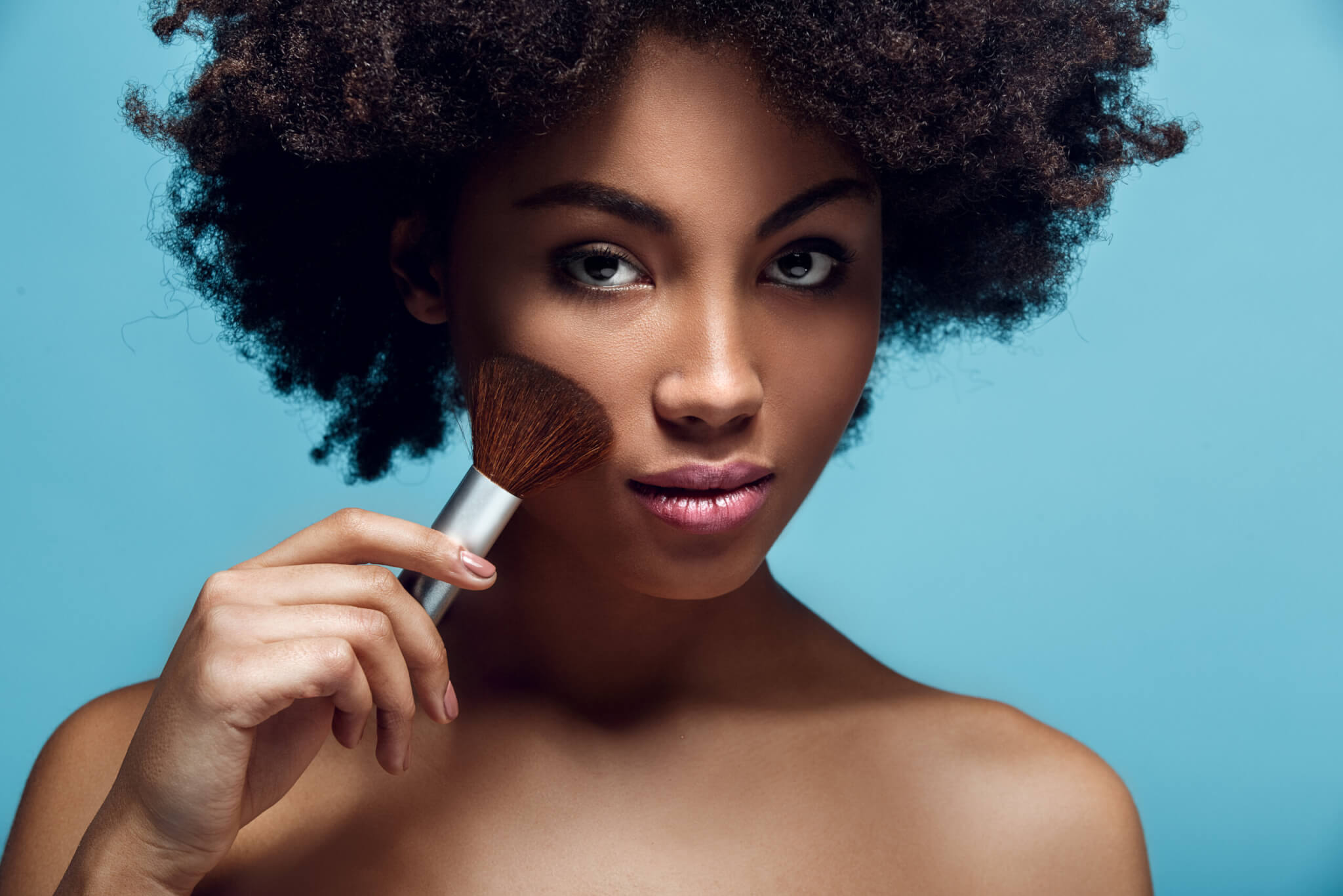 Black woman applying makeup