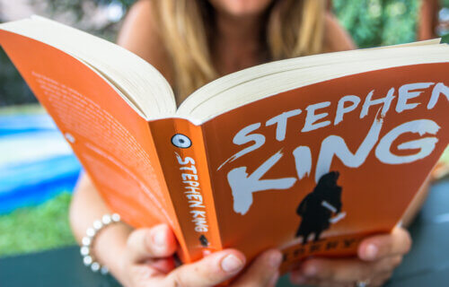 A woman reading "Misery" by Stephen King