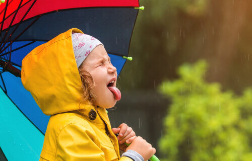 Little girl sticking her tongue out in the rain