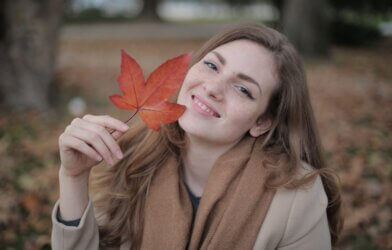 A woman holding a fall leaf