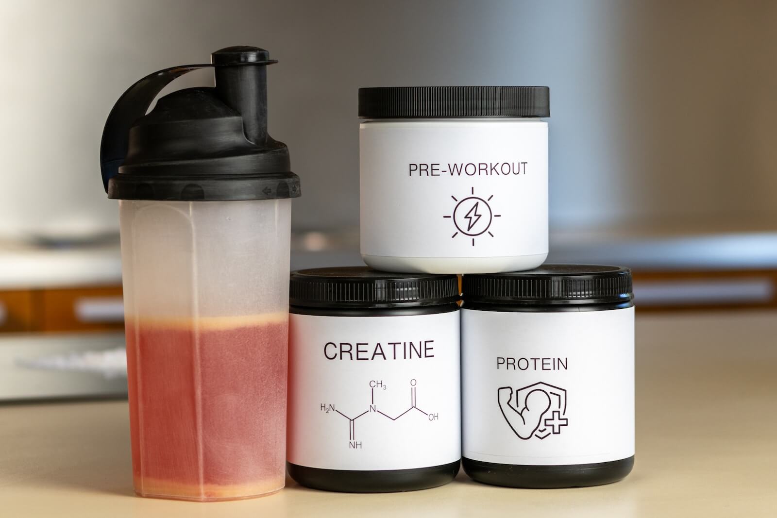 three containers of protein powder