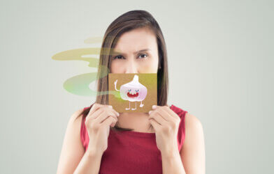 Woman holding a garlic cartoon picture, Bad breath