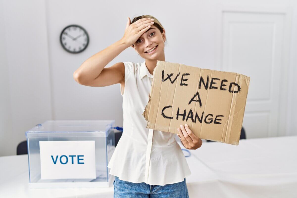 Young woman at political election holding we need a change banner