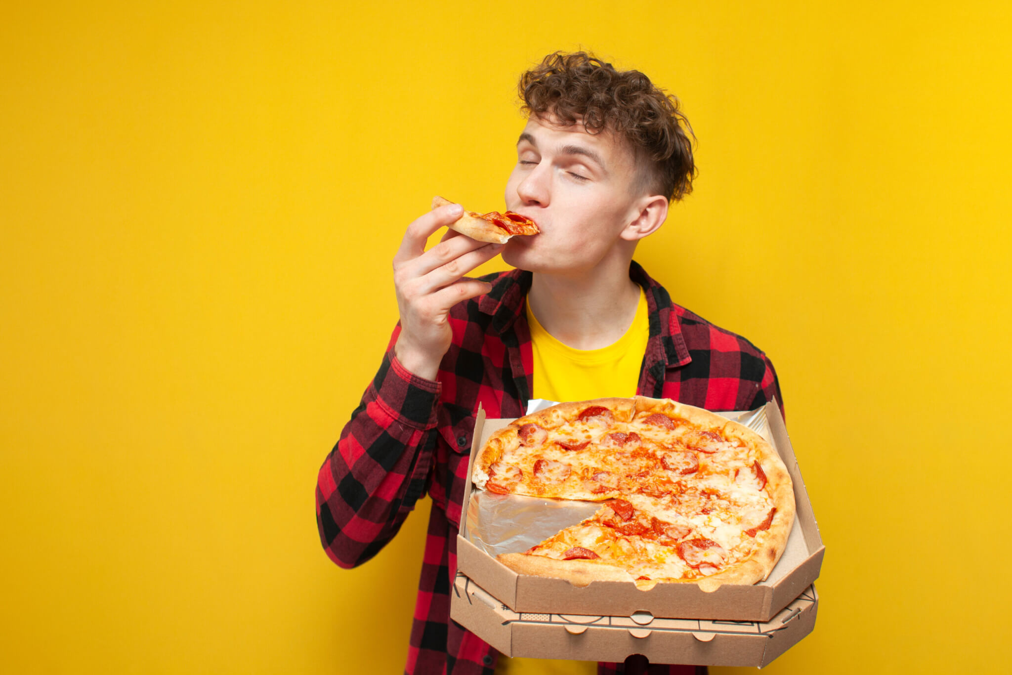 young guy eating pizza