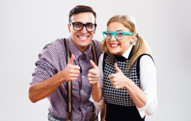 Happy nerdy couple showing thumbs up