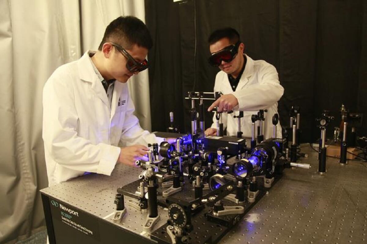 picture of two researchers working on a ver y large camera set on top of a long table