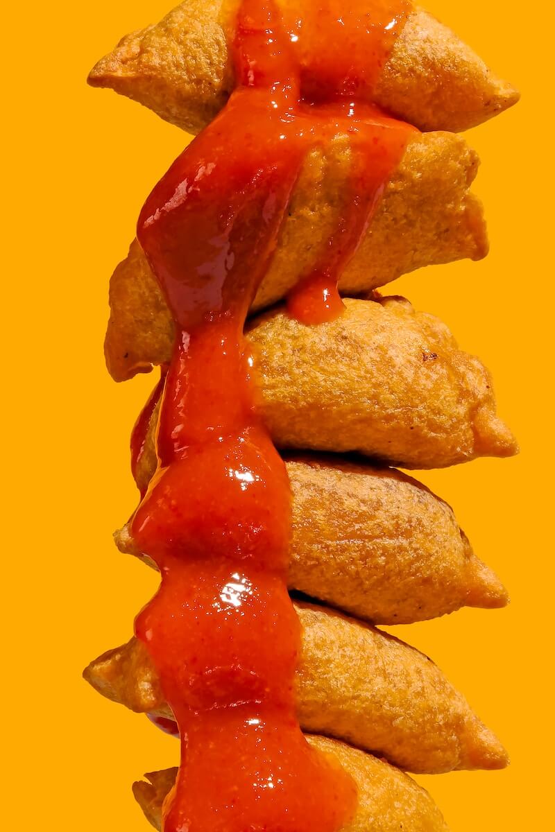 A fried snack drenched in hot sauce