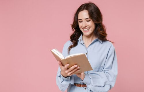 A woman laughing while reading