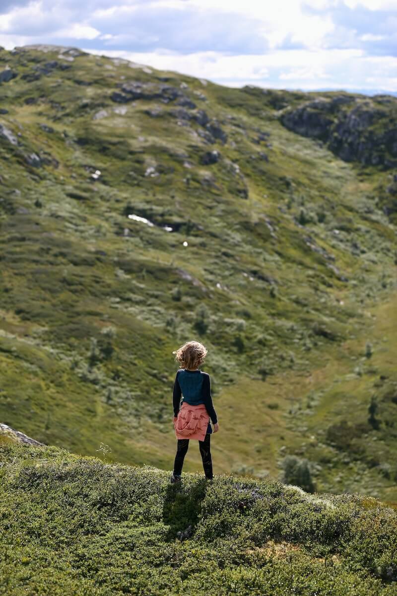 A young girl standing on a hillside