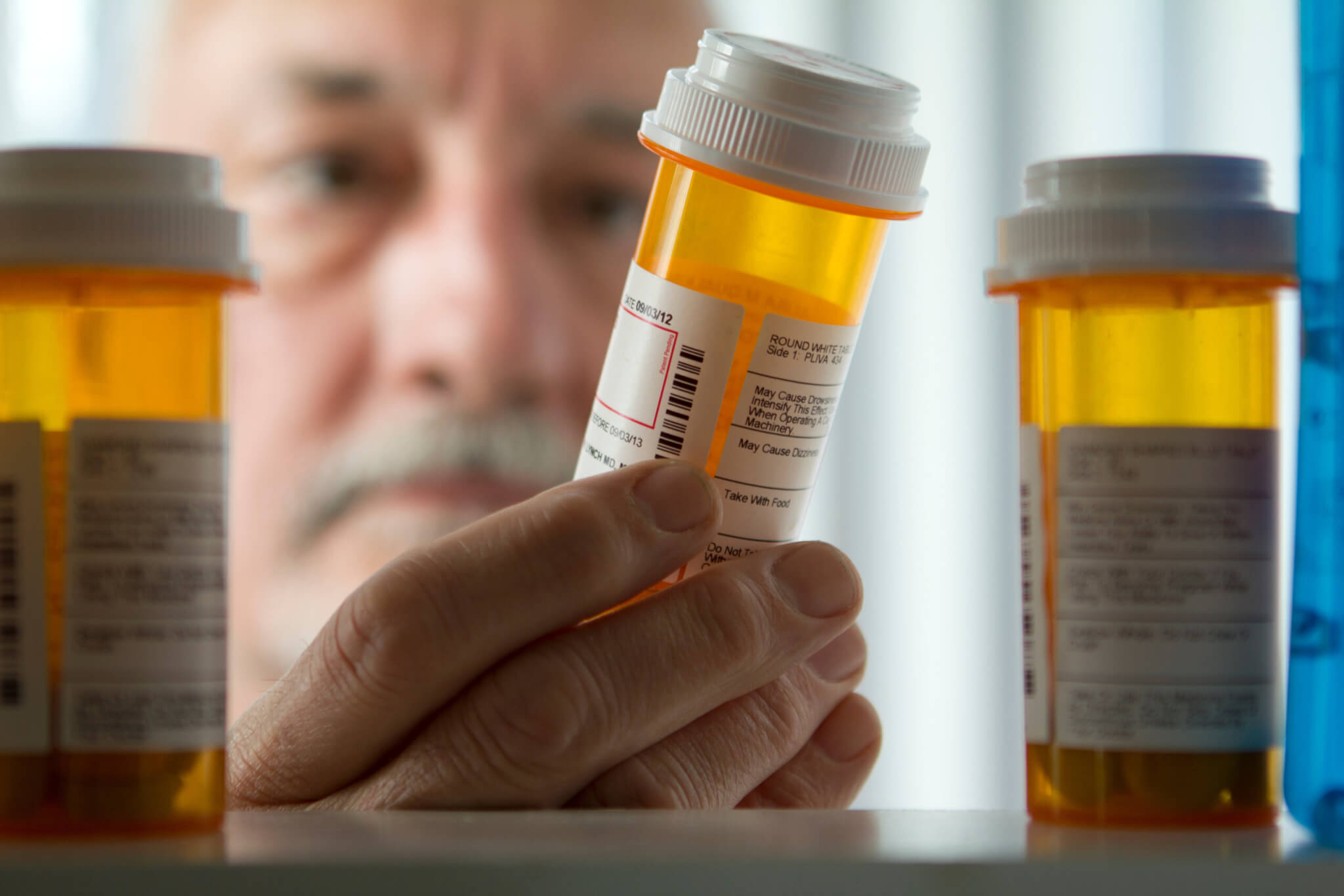 Man reaching for prescription from medicine cabinet