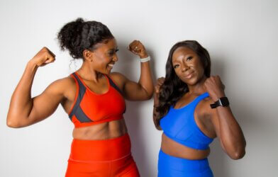Two women wearing sports bras and leggings