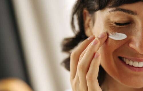 Woman applying cream under her eye