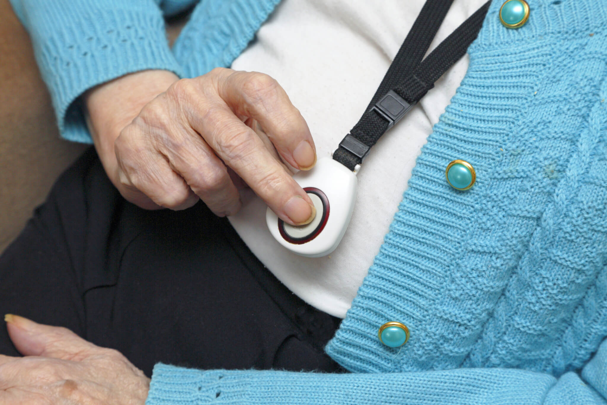 A senior pressing a medical alert button