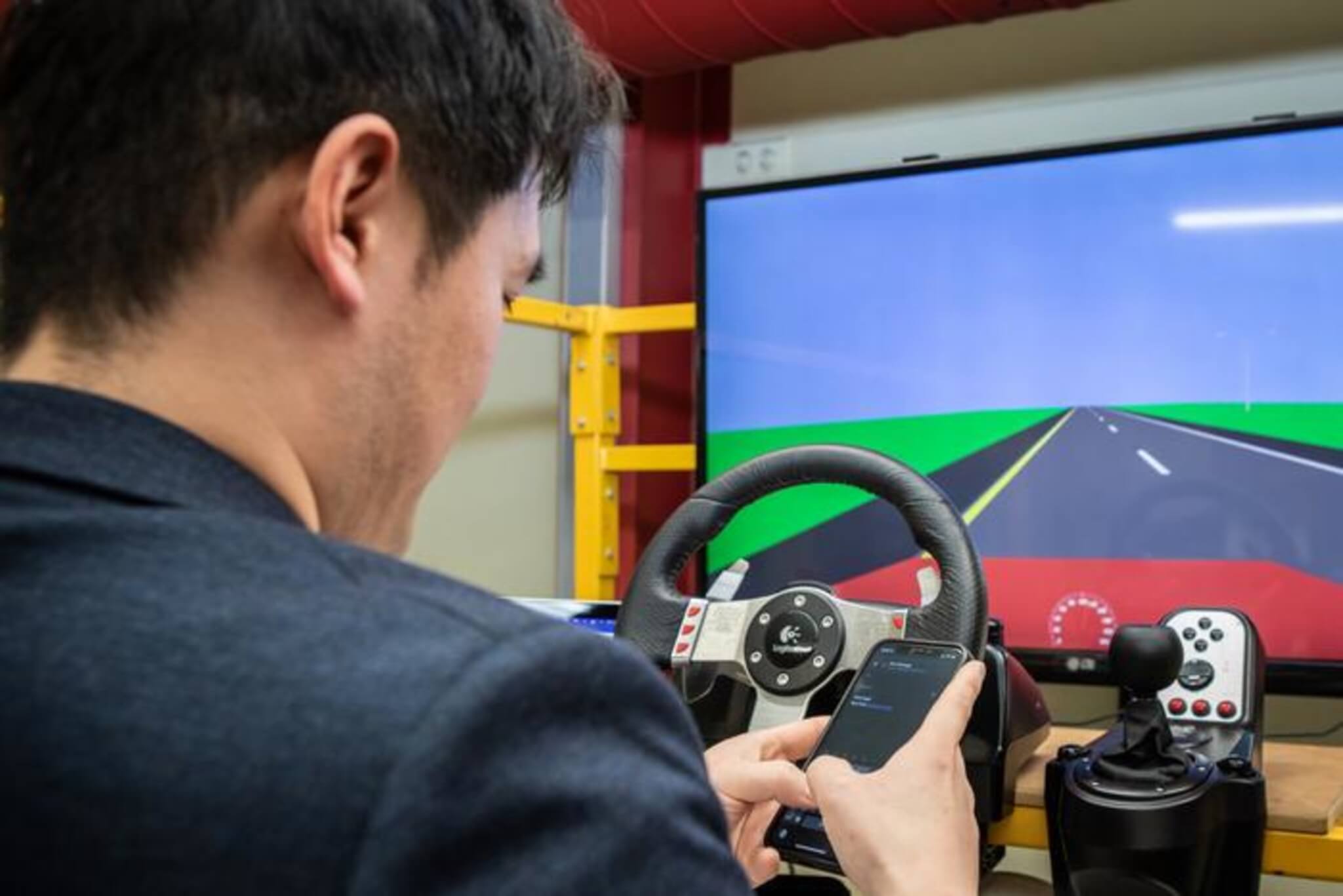 Lead study author, Dr. Neng Zhang, demonstrates social media use in the automated vehicle simulator