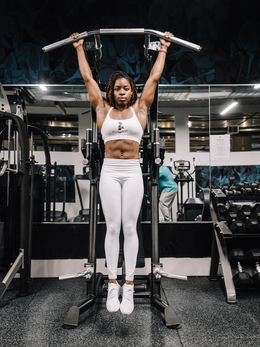 Woman performing pull-ups while working out at the gym